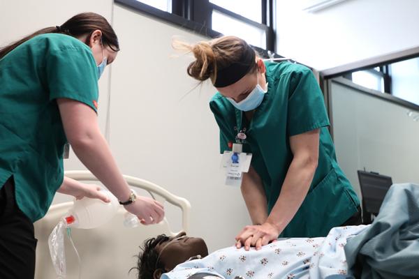 护理 students performing respiratory procedures on a mannequin 