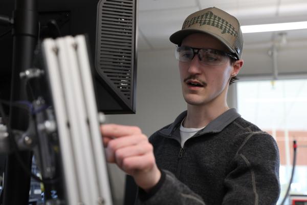 Master's student pointing at a computer screen